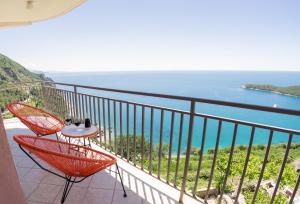 布德瓦Apartments Villa Vanja的阳台设有红色椅子,享有海景。