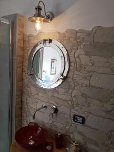 圣玛丽亚纳瓦雷B&B Cara'a mare的浴室设有水槽和石墙上的镜子