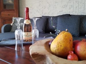施托尔佩奥夫乌塞多姆Kleine Auszeit的一张桌子,上面放着一瓶葡萄酒和一碗水果