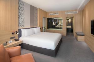 乔治市格尼G酒店的卧室配有一张白色的大床和一张沙发。