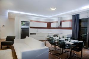 库萨达斯Pine City Residence的客厅配有白色的沙发和桌子