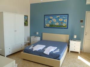 特拉比亚Casa Michela, sea-view apartments的一间卧室拥有蓝色的墙壁,配有一张带两个枕头的床