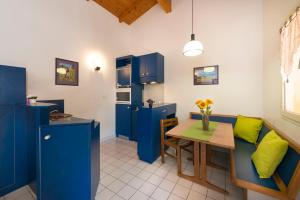 蒙布兰莱班Village Vacances Leo Lagrange的厨房配有蓝色橱柜和带绿色枕头的桌子