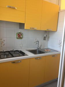 特拉比亚Casa Michela, sea-view apartments的厨房配有黄色橱柜和水槽