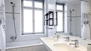 布尔诺多沃拉科瓦酒店的白色的浴室设有两个盥洗盆、浴缸和窗户。
