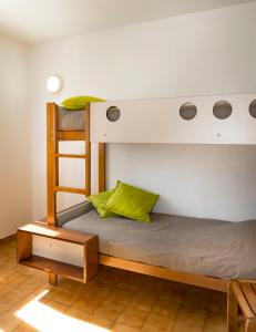 蒙布兰莱班Village Vacances Leo Lagrange的一间卧室配有两张双层床和绿色枕头