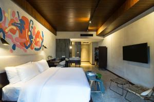 乌布ARTOTEL Haniman Ubud的卧室配有白色的床和平面电视。