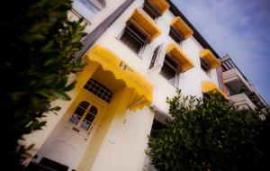 杜塞尔多夫卡尔顿梅费尔酒店的一座高大的白色建筑,设有黄色的门窗