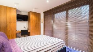 伦敦诺丁山浪漫旅馆的一间卧室配有一张床、一张书桌和一台电视