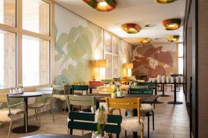 蒂罗尔州霍尔希韦斯特酒店的餐厅设有桌椅和窗户。