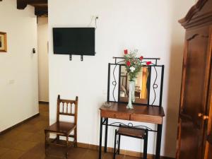 阿尔科斯-德拉弗龙特拉Hotel Restaurante Calderon的一间设有花瓶的桌子和电视的房间