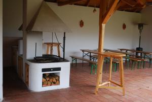 Sarród罗扎利亚温德哈兹旅馆的配有桌子和桌子的房间的燃木炉