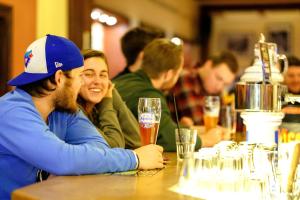 慕尼黑慕尼黑欧洲青年旅馆的坐在桌子旁喝杯啤酒的男人和女人