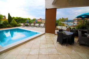 索佐波尔Luxury House on Buzhaka的庭院设有游泳池和桌椅