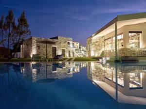 卡拉马孔Golden Sun Resort - Adults Only的夜间带游泳池的建筑的 ⁇ 染