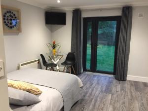 本拉提Tudor Lodge Guest Accommodation的一间卧室设有一张床和一个滑动玻璃门