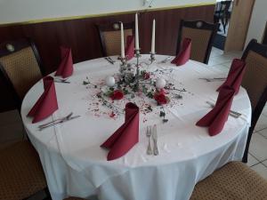 卑尔根Mühlwinkler Hof的一张白色的桌子,上面有红色的餐巾和鲜花