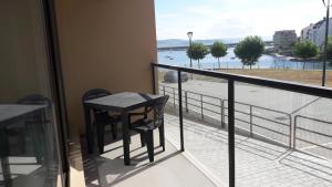 孔门波尔多托瑞斯珂奥斯莫公寓酒店的阳台配有桌子,享有水景