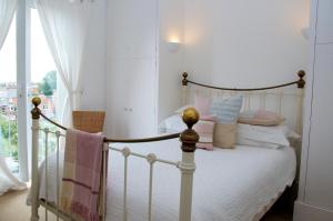 考斯一五零酒店的一间卧室配有带粉色和白色枕头的床