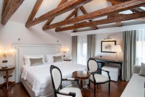 威尼斯卡萨维拉尔朵德波卡住宅酒店的卧室配有一张床、一张桌子和椅子