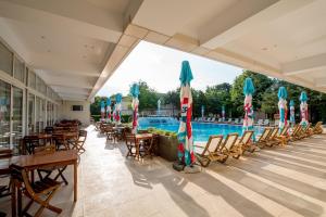 尼普顿Club de Vacanta Mediterraneo的一个带游泳池、椅子和遮阳伞的度假村