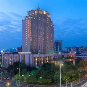 东莞东莞石碣富盈酒店的一座高大的建筑,晚上在城市里亮着灯