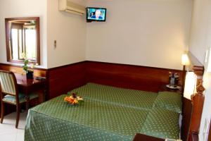 卢切拉Balconata 2.0 Banqueting & Accommodations的一间卧室配有一张绿色的床,墙上配有电视
