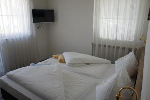 西兰德罗Pension Pernthaler的一间卧室配有两张带白色床单的床和电视。