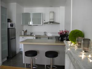 博讷Les chanceliers Duplex的厨房配有2把吧台凳和台面