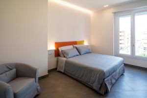卡利亚里Centro storico via Sassari Accommodation的卧室配有床、椅子和窗户。
