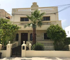 圣保罗湾城Villa Zammitella的前面有棕榈树的白色房子