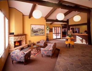 白马村白马高山宾馆的客厅配有椅子和壁炉