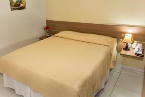 雅克南Pousada Villamor - Naturista Liberal (Adult Only)的卧室配有白色的床和木制床头板