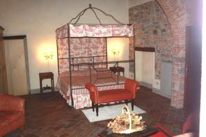 博尔戈圣洛伦索洛坎达迪阿尔伯瑞住宿加早餐旅馆的一间卧室配有天蓬床和两张红色椅子