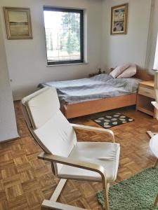 马里博尔Gostisce Sobocan的一间卧室配有一张床和一张白色椅子