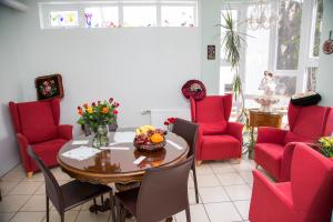 雷克雅未克蝴蝶旅馆的一间用餐室,配有红色的椅子和桌子