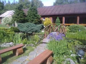 拉伊恰Ośrodek Wczasowy "GRONOSTAJ"的一座带木桥和木板凳的花园