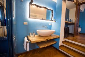 切奇纳Villa Mandrioli的浴室设有水槽和蓝色墙壁上的镜子