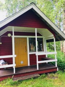 凯里迈基Ollila Rantamökit的红色小屋设有门廊和门