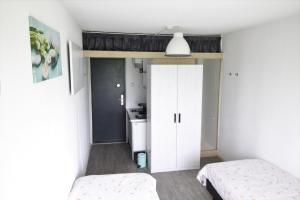 DrijberTiny Cottage op Camping "De stal"的一间卧室配有两张床和一个白色衣柜