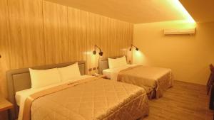 高雄旅港汽车旅馆的一间酒店客房内设有两张床的房间