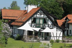 ZawadySzwajcaria Mazurska的前面有白色遮阳伞的房子