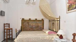 金尼昂Anemos and Almyra的一间卧室,配有一张带挂毯的床