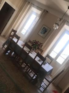 切尔维奥内巴拉玛塔酒店的餐桌、两把椅子和两扇窗户
