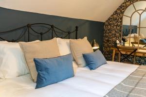 雷丁公牛旅馆的一间卧室配有一张带蓝色和白色枕头的床