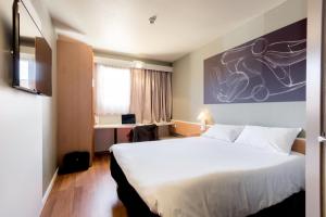 格拉纳达宜必思格拉纳达酒店的酒店客房设有一张大床和一张书桌。