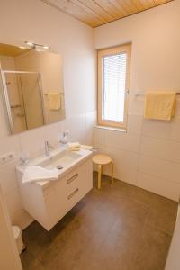 哈德Gästehaus Gritsch的白色的浴室设有水槽和镜子