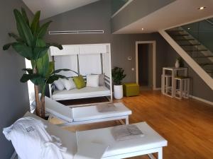 瓦伦西亚BONNIES Suites & Spa Valencia的客厅设有白色沙发和楼梯。