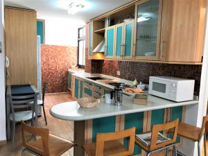 阿格特Nature Vista Agaete & Parking的厨房配有带椅子的柜台和微波炉