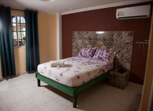 巴拿马城图瑞斯提可库巴酒店的一间卧室配有一张紫色床单的床